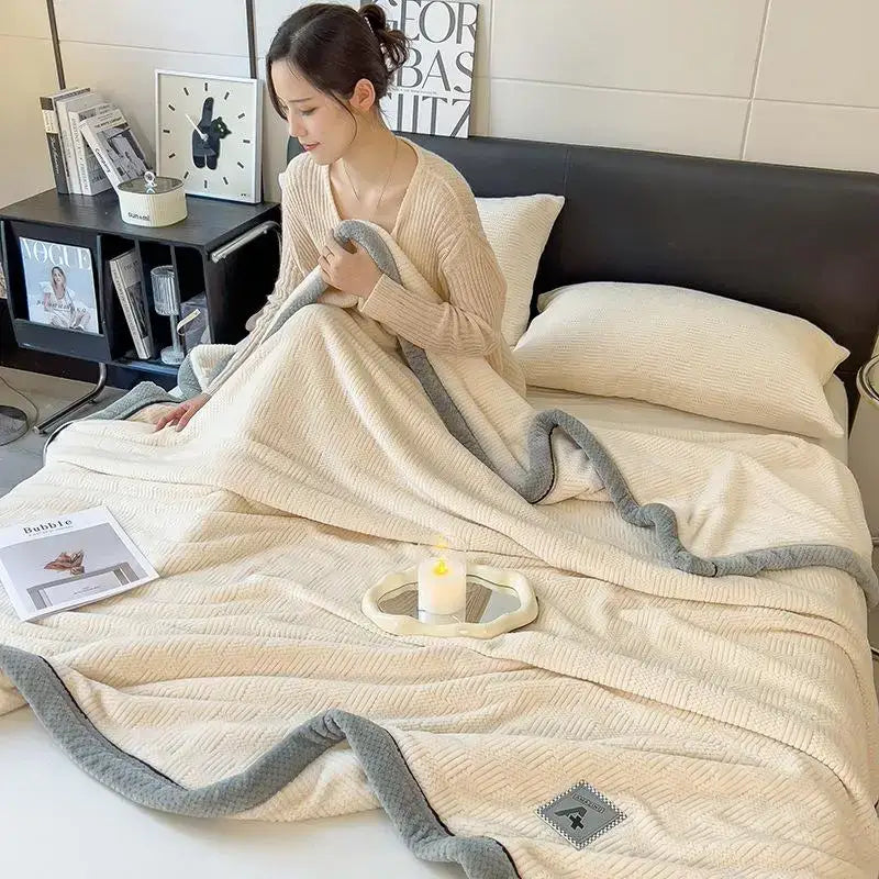 Cream-colored plush blanket with soft textured weave and gray ribbed border made of cozy cotton velvet decorbites plush blanket