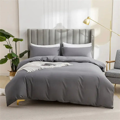 Gray tufted velvet bed with matching gray duvet and white pillows featuring a quilted tan duvet cover set for soft bedding