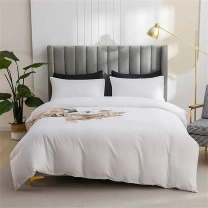Gray tufted velvet headboard with black pillows and white bedding complementing quilted tan duvet cover set for soft bedding