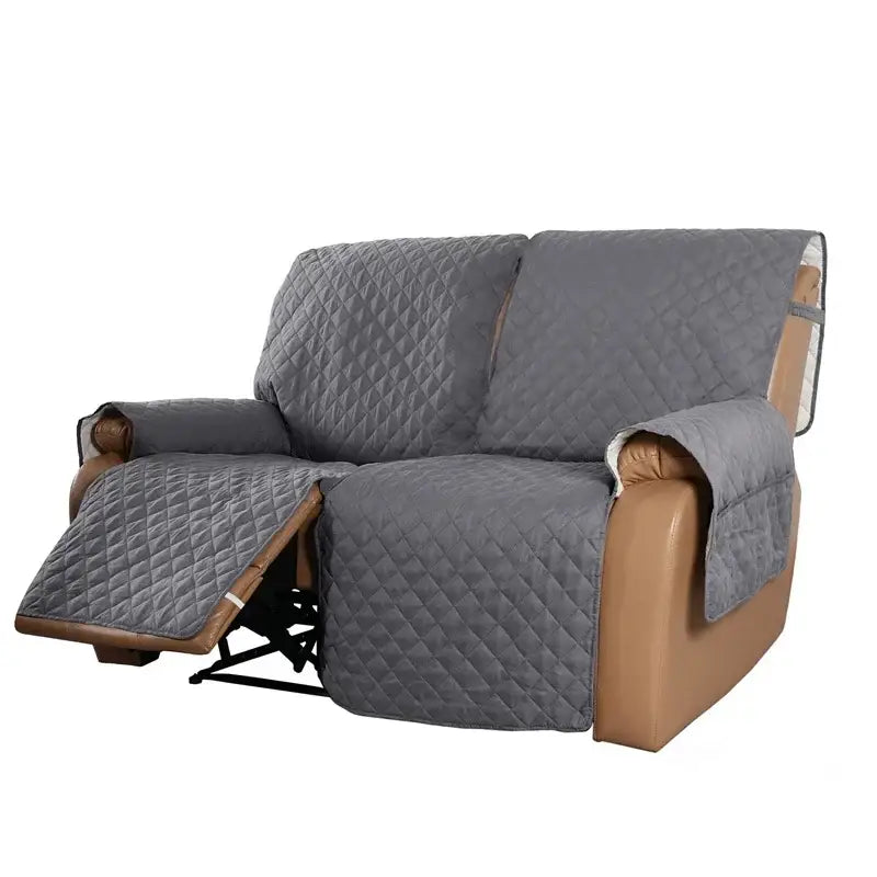 Gray quilted fabric sofa protector with diamond-stitched pattern and brown leather trim for living room recliner slipcover