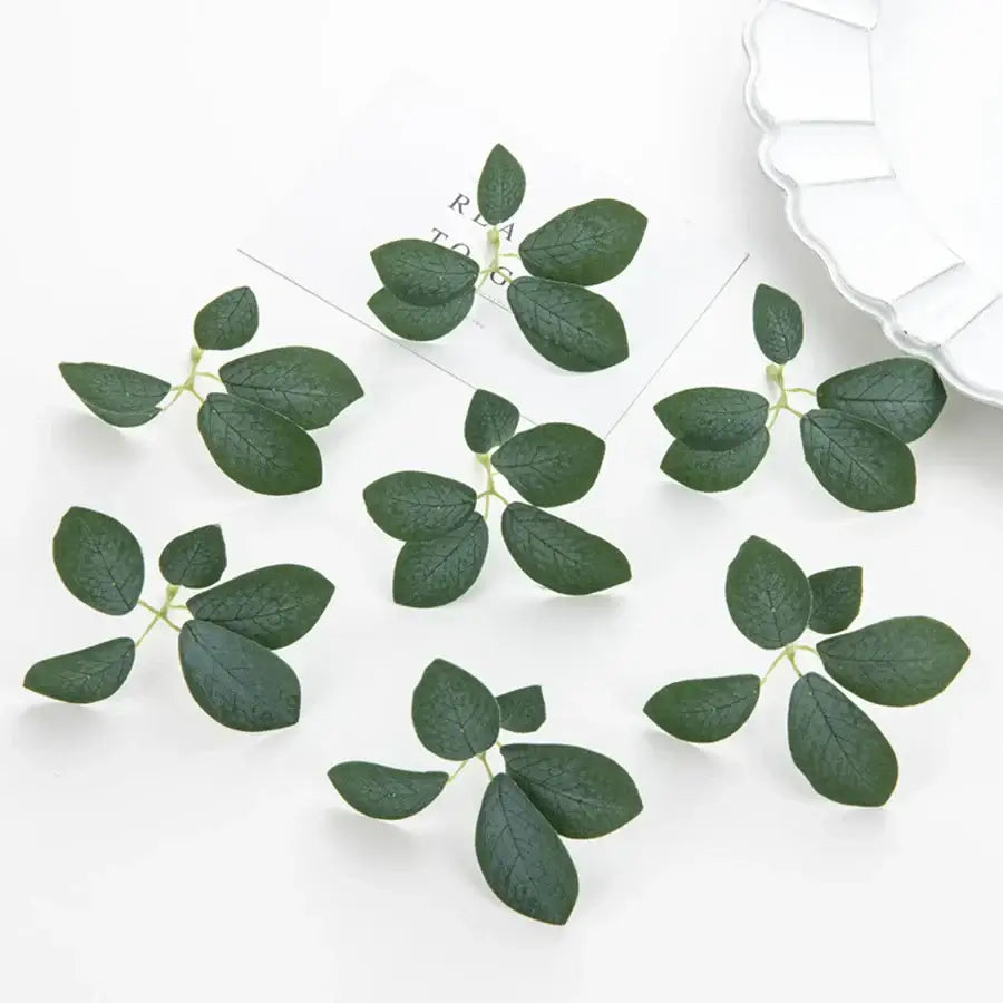 Dark green 50pcs silk 5leaf artificial roses with realistic veining and delicate stems arranged on white surface