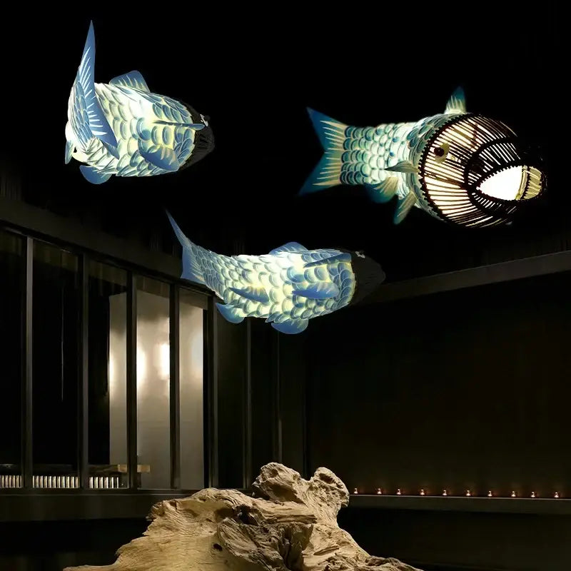 Red bamboo fish pendant light features three illuminated bamboo fish pendant lanterns with detailed scale patterns