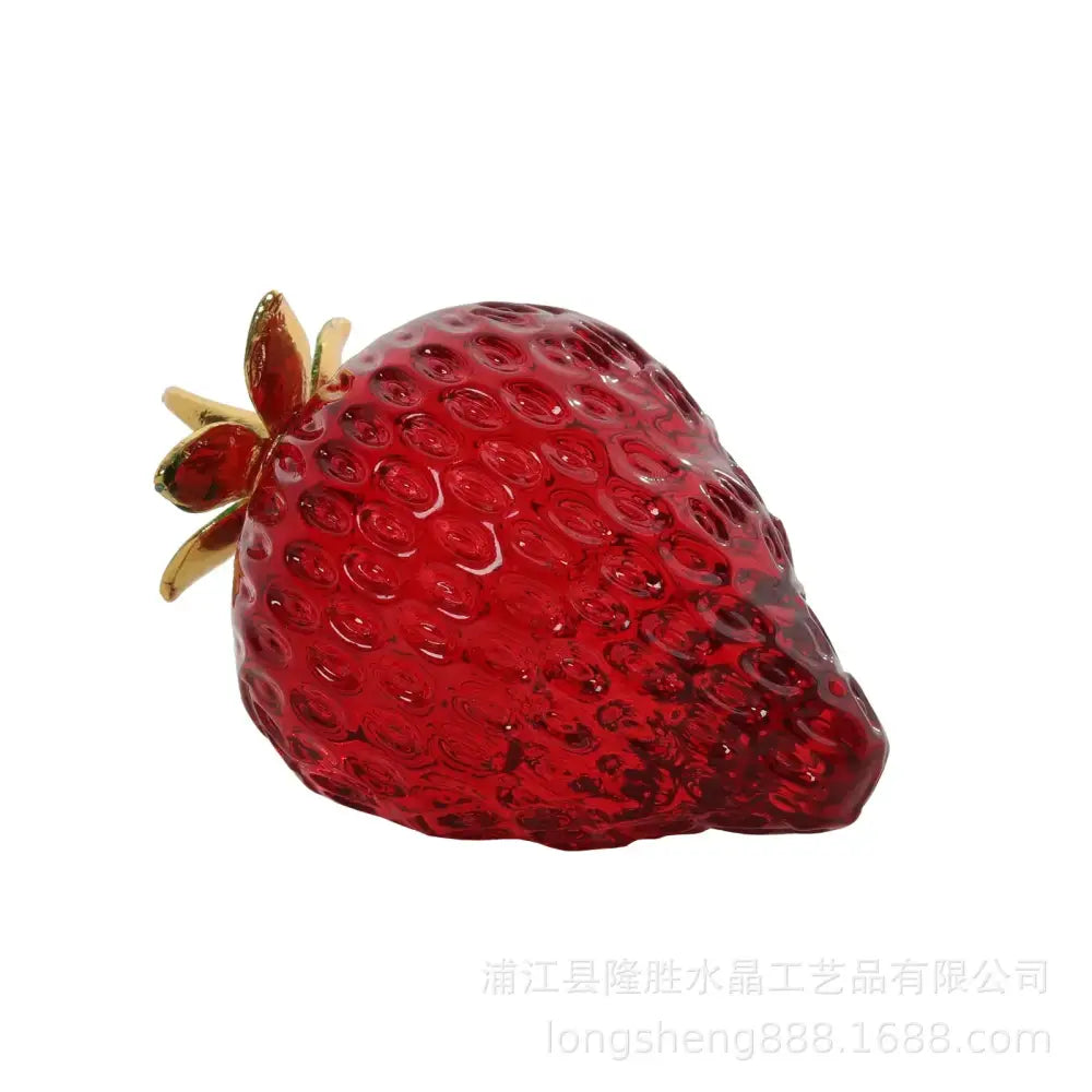 A translucent red glass red strawberry figurine with gold-toned stem and leaf detail crystal fruit ornament