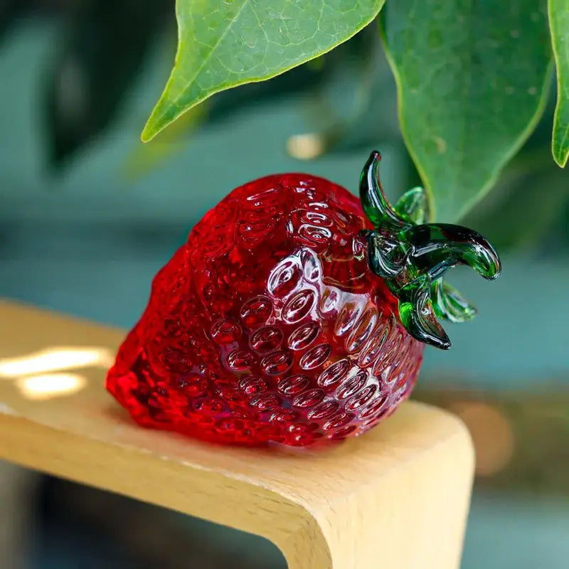 Red glass strawberry figurine with vibrant crystal fruit body and detailed green leafy stem for kitchen decor