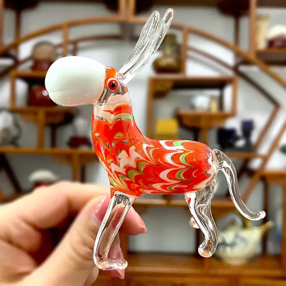 A vibrant red white and green swirl glass donkey figurine with clear glass legs ears tail holding a white bubble