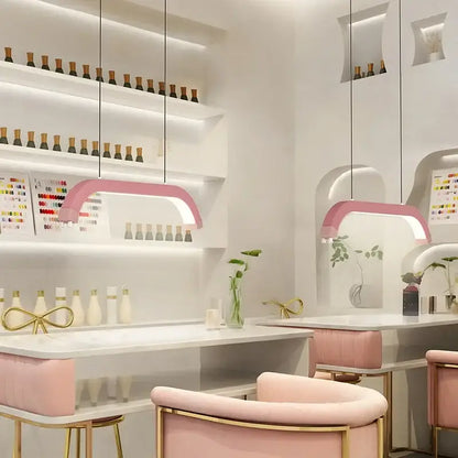 Refined modern pink arched led pendant light with sleek design and soft glow for beauty studio use