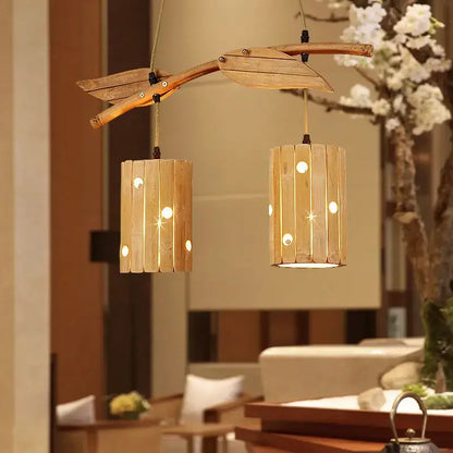 Retro bamboo art chandelier featuring a natural wood branch design with two slatted bamboo lanterns emitting warm light