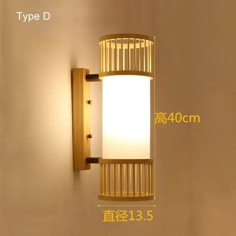 A warm-toned cylindrical bamboo wall lamp with a frosted glass shade and hand woven rattan design for bedrooms