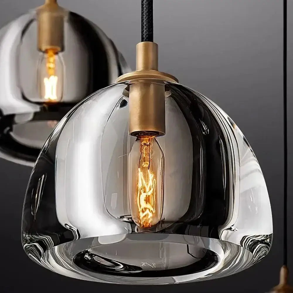 A sleek decorbites black brass retro pendant light with hand-blown glass and exposed edison bulb for dining room