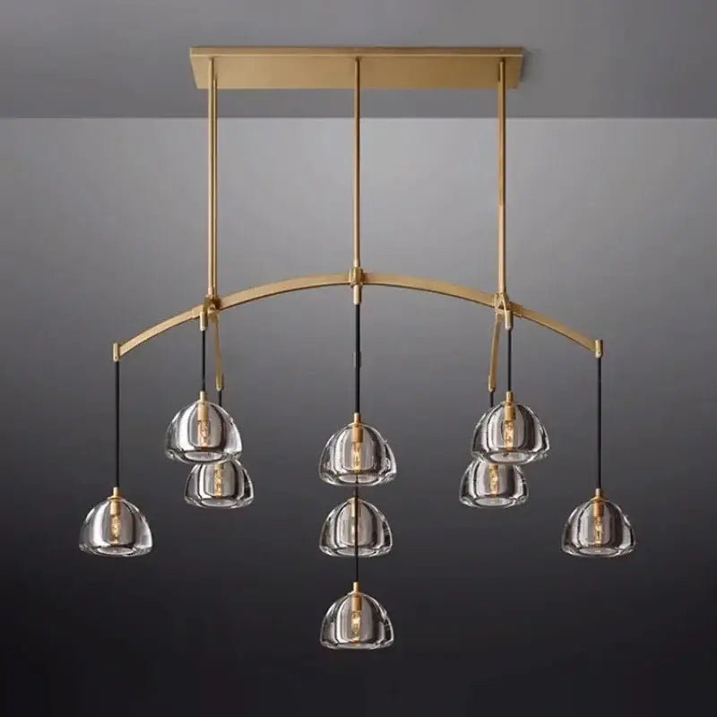 Retro black brass pendant light with gold-toned chandelier, clear glass dome shades, and black cords for dining room decorbites black brass