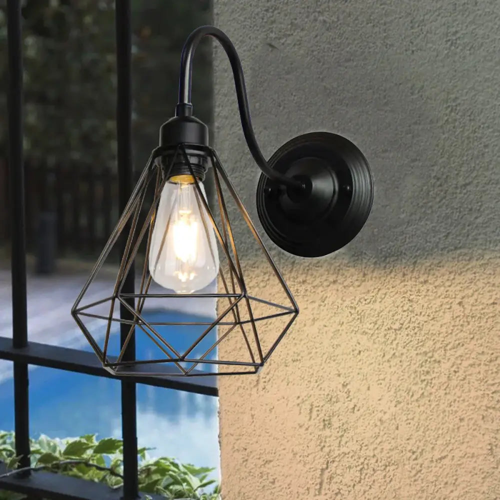 Retro black cage guard wall sconce with a black wrought iron geometric cage and exposed filament bulb for bedroom decorbites black cage