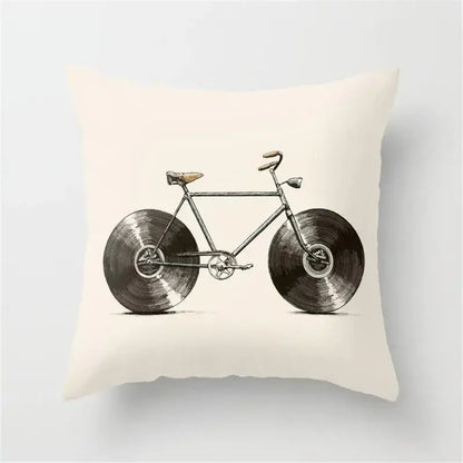 Cream-colored cushion cover with vintage-style bicycle and black camera print featuring vinyl record wheels for decor