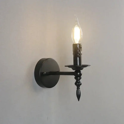 Retro black iron art wall lamp featuring a black wrought iron candlestick-style sconce with a glowing filament bulb