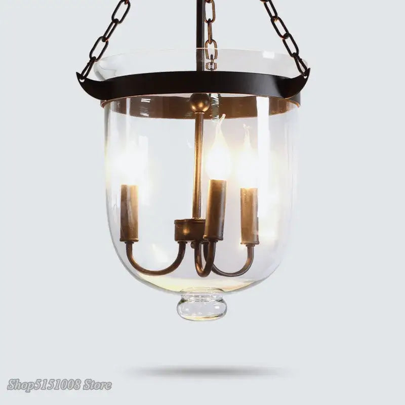 Antique brass-finished pendant light with clear glass bell-shaped shade and three candle-style bulbs for dining decorbites glass bucket pendant