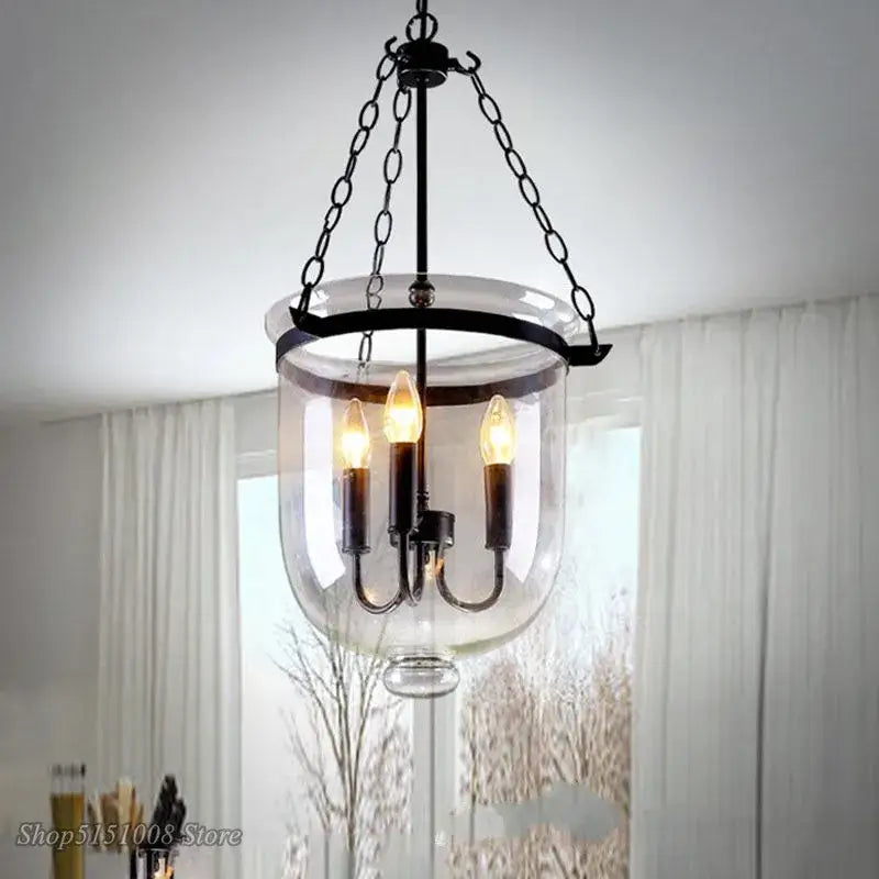 Retro black metal glass bucket pendant light with clear enclosure and three lit candle-style bulbs for dining room decorbites glass bucket
