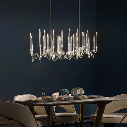 Modern crystal chandelier with slender glass arms and metallic frame complements retro black rattan chair puma cushion decorbites crystal candle