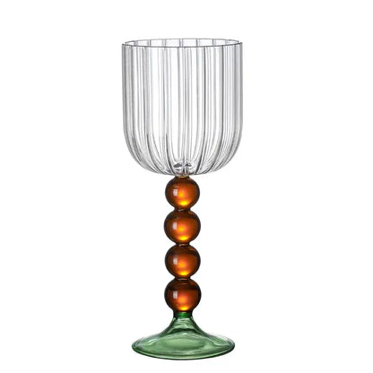 Clear glass wine glass twister with vertical ribbed texture amber beads on stem and green tinted base for dining room use