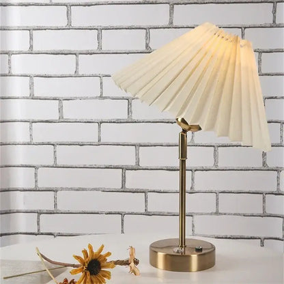 Cream-colored pleated table lamp with brass-finished base and adjustable pleated design for decorbites adjustable pleated use