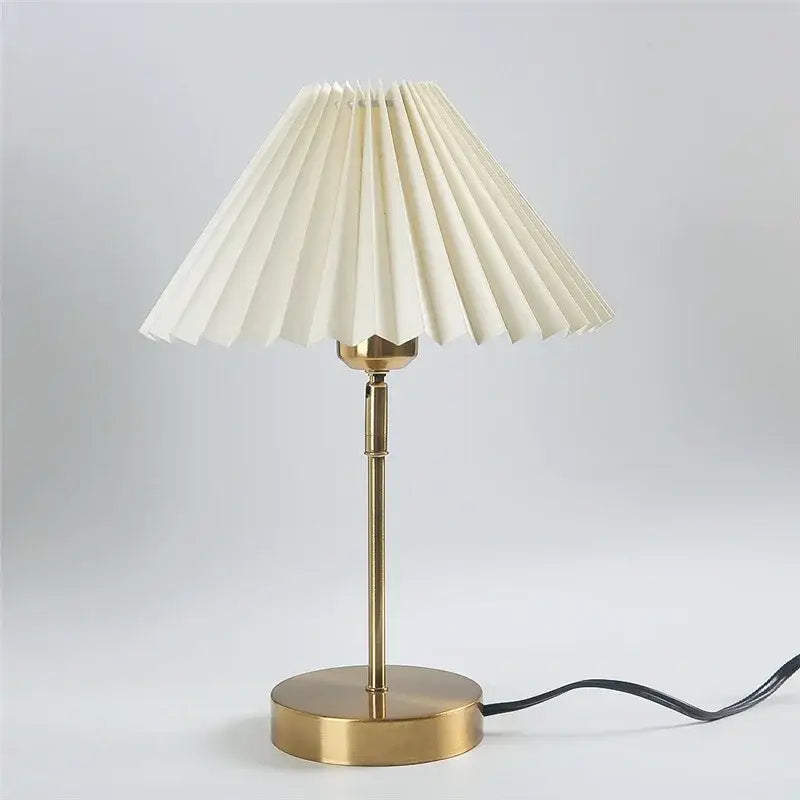 Cream-colored pleated table lamp with adjustable brass-finished base ideal for retro bedroom lighting