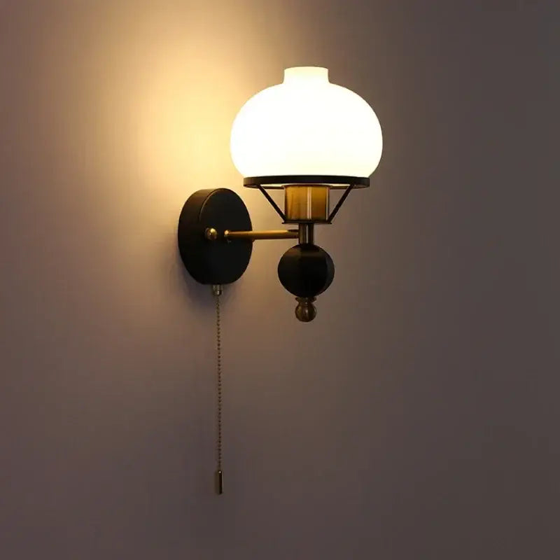 Warm-toned globe glass wall lamp with brass and black metal frame perfect for decorbites french wall lamp settings