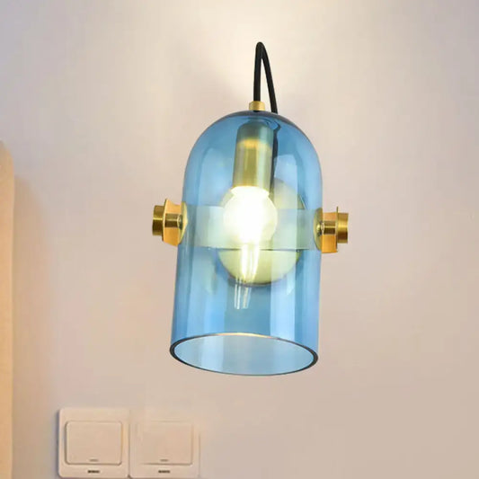 Retro brass cloche sconce light with blue glass and visible bulb featuring brass accents for bedroom use