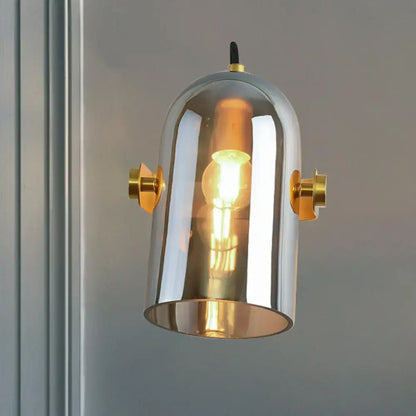 Retro brass cloche sconce light with blue glass and chrome finish featuring gold accents and exposed filament bulb