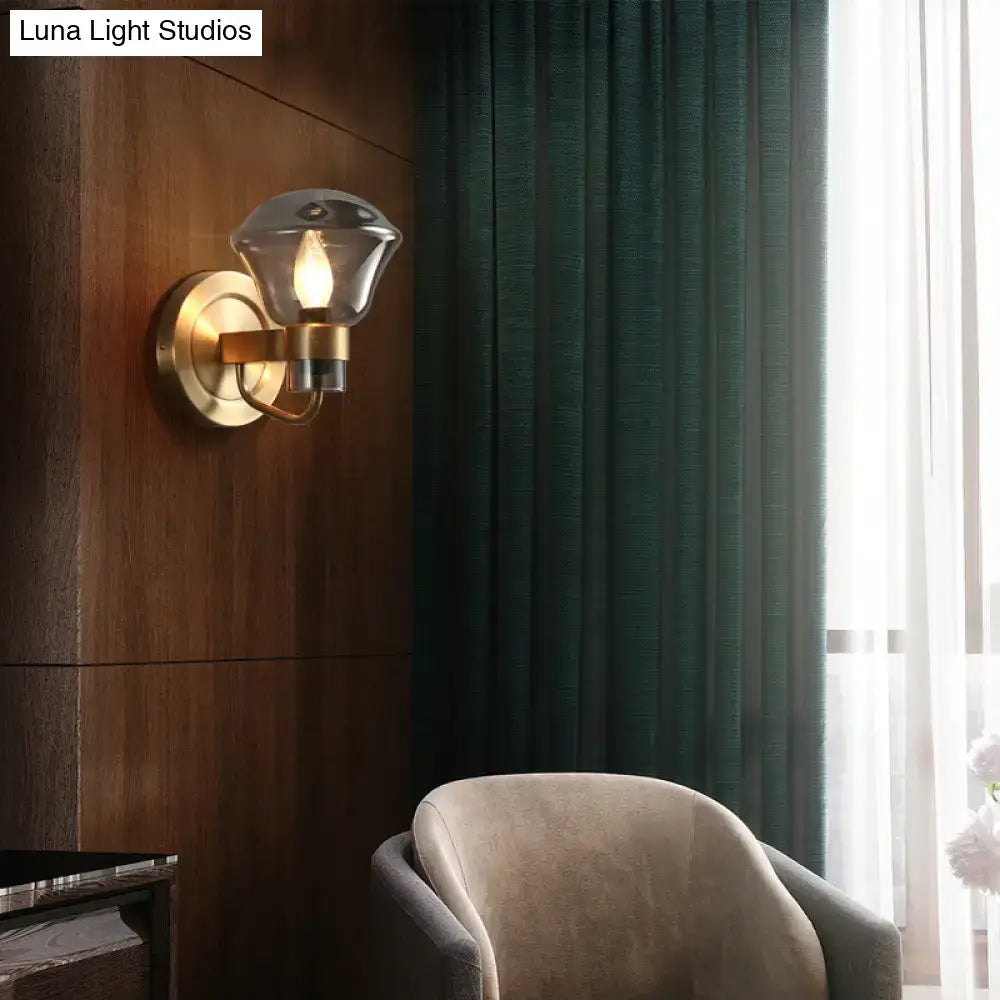 Brass-finished wall sconce with a faceted smoke gray amber glass shade for retro bedroom light fixture