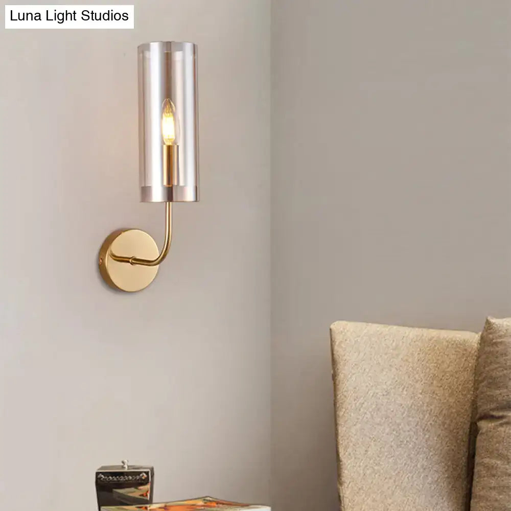 Modern wall mount lamp with gold-toned metal base and cylindrical smoked glass shade for living room lighting
