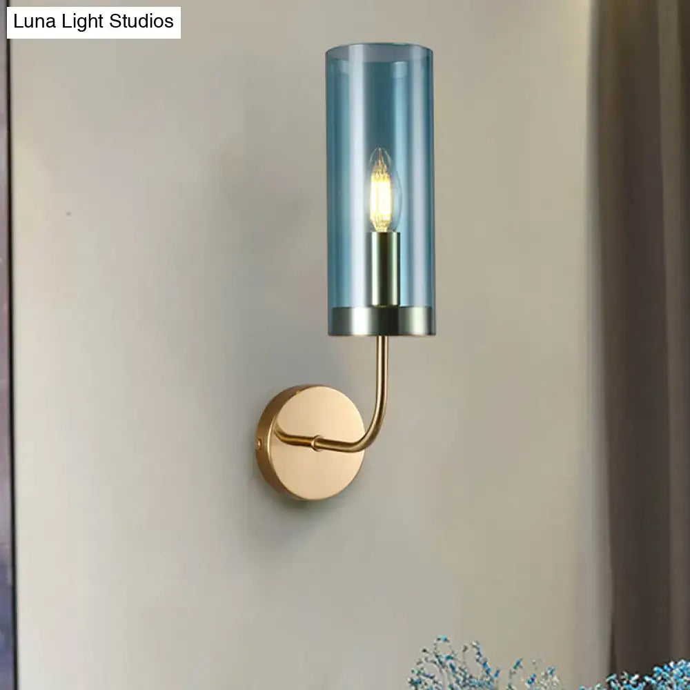 Blue cylindrical smoked glass wall mount lamp with brass finish metal base and arm for living room use