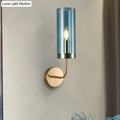 Blue cylindrical smoked glass wall mount lamp with brass finish metal base and arm for living room use