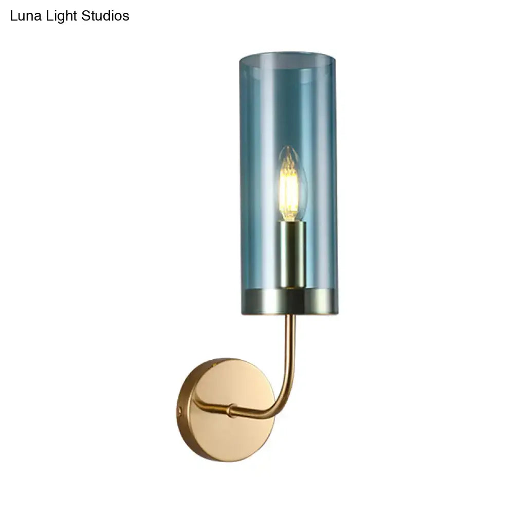 Retro brass wall mount lamp with smoked blue glass shade and exposed bulb on a curved brass arm for living room