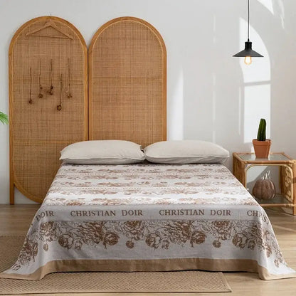 Beige and brown floral-patterned christian dior bedspread with woven rattan headboard and decorbites cotton throw blanket
