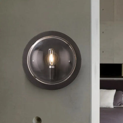 Retro dark gray metal wall sconce with clear glass shade and exposed filament bulb for living room lighting