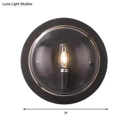 Retro dark gray metal wall sconce featuring a clear glass shade with an exposed edison-style bulb for living room use