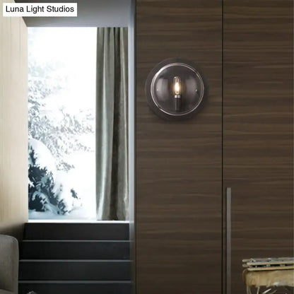 Retro dark gray metal wall sconce with clear glass shade and exposed filament bulb for living room lighting