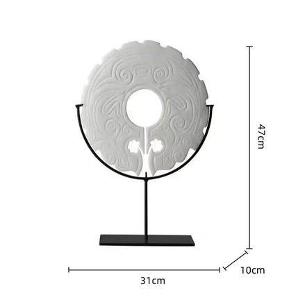 A white intricately carved circular geometric totem resin statue on a black stand for retro living room decorbites decor