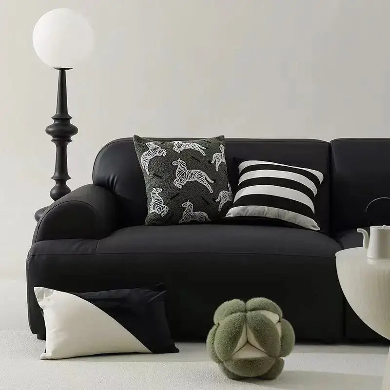 Black leather sofa with retro dark green zebra embroidered jacquard luxury pillow cover and plush cushion