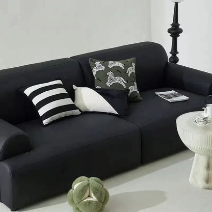 Black upholstered sofa with plush cushions and retro dark green zebra embroidered jacquard luxury pillow covers