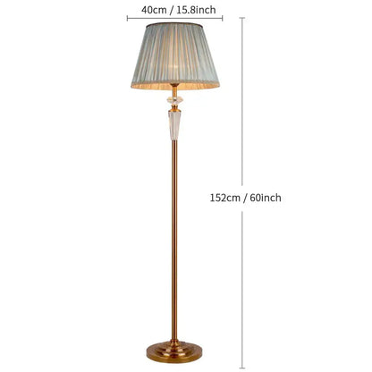 A tall retro emerald green and gold crystal floor lamp with a brass base and pleated gray fabric shade for decorbites decor