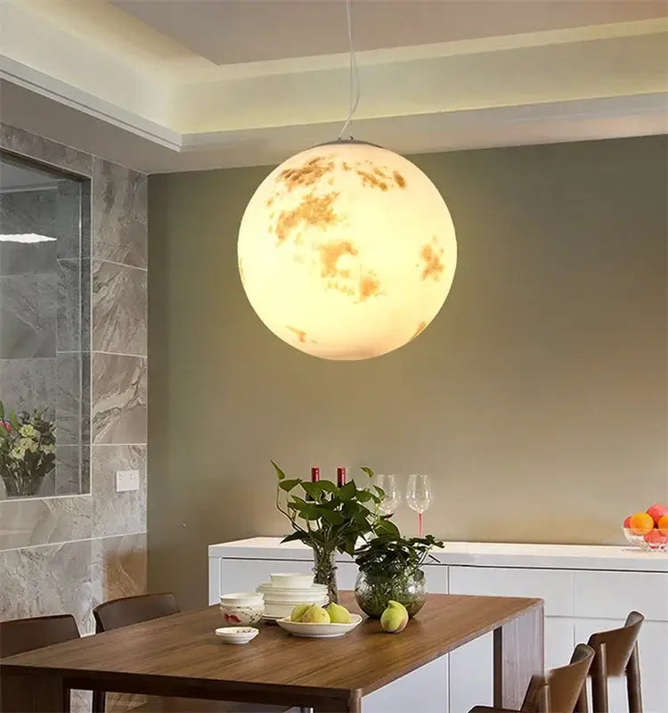 Retro full moon chandelier pendant light with detailed craters glowing warm yellow for modern home dining rooms