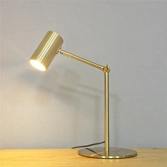 Retro gold adjustable angle floor lamp with gold finish cylindrical head and slender articulated arm for reading light