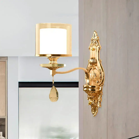 Gold-finished ornate wall mount lamp with frosted glass shade and teardrop crystal pendant for living room use