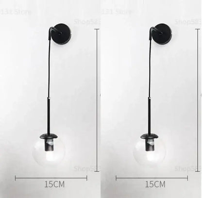 Black wall lamp with decorbites glass ball clear globe and slender metal stem for bedroom smoked sconce decor