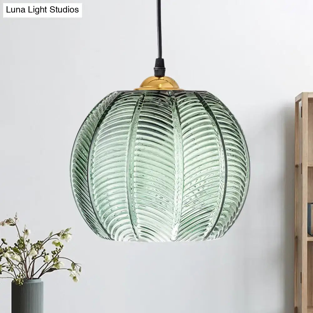 Retro green ribbed glass pumpkin dinette pendant lamp with translucent green glass and gold-toned fixture