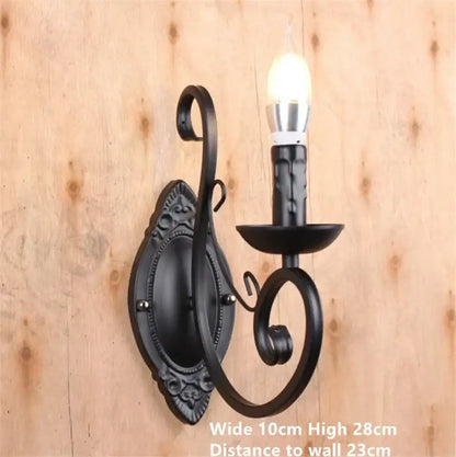 Black wrought iron wall sconce with ornate scrollwork and candle-style bulb for retro industrial decorbites decor
