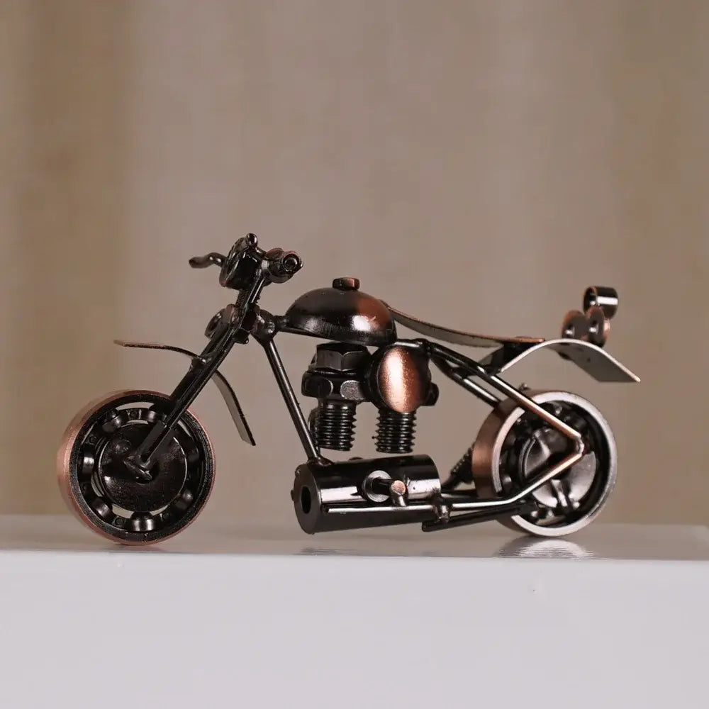 Rustic metal figurine of a retro motorcycle model with black and copper finish made from repurposed mechanical parts