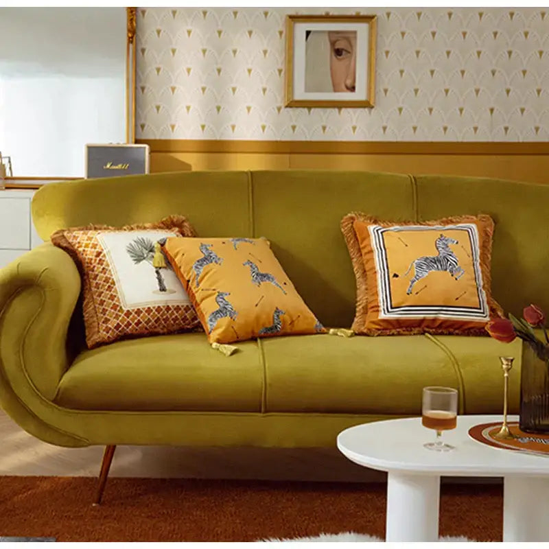 Olive green velvet sofa with curved arms and tapered legs featuring retro mustard and zebra print cushion cover decorbites italian retro