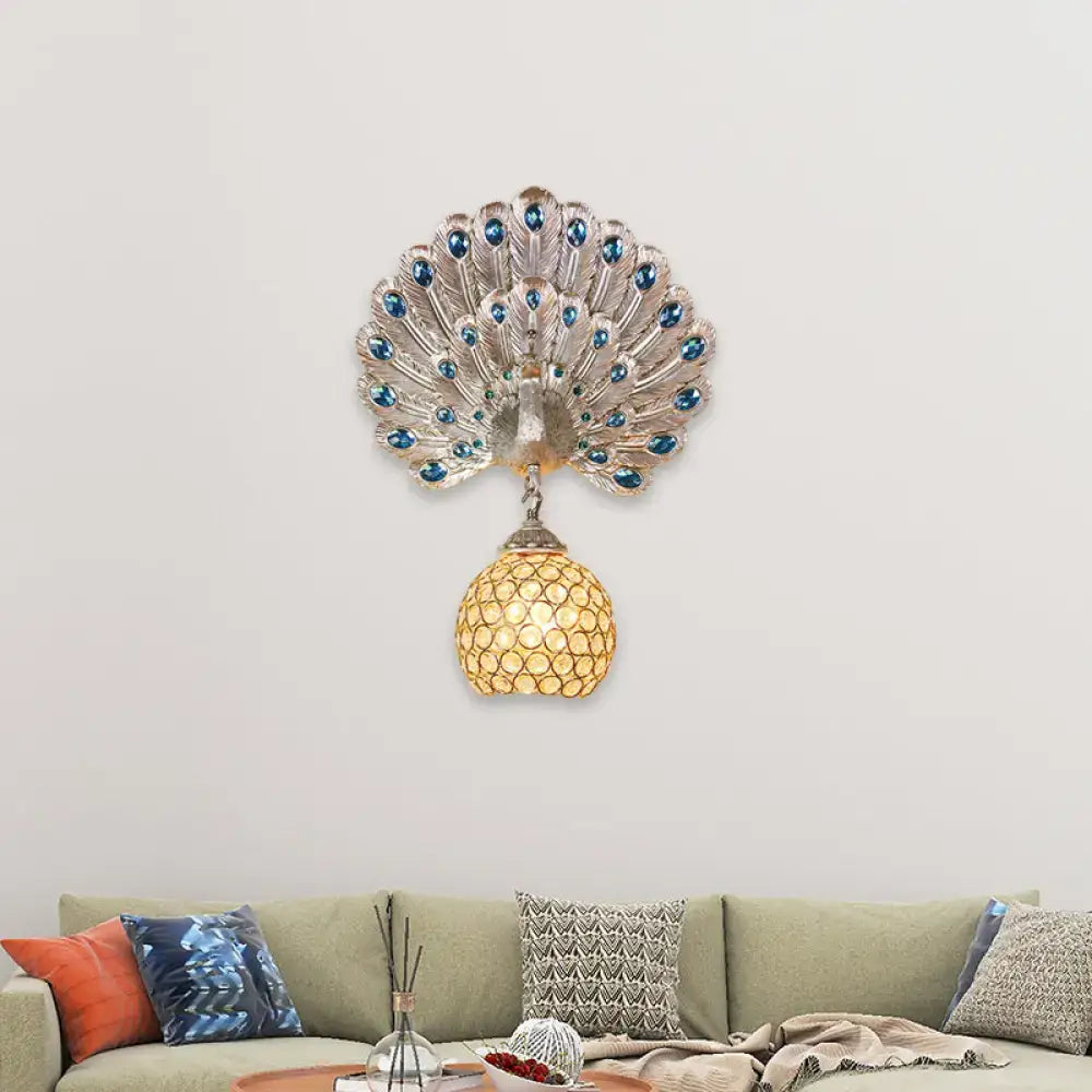 Silver peacock wall lamp with blue gemstone eyes, clear crystal details, golden mosaic shade, and peacock backplate for living room