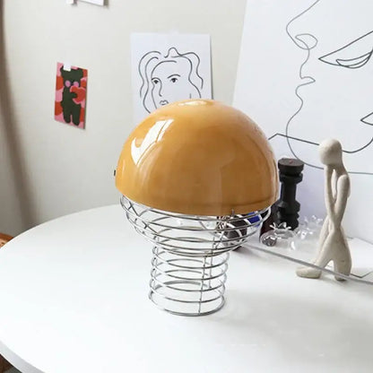Glossy mustard-yellow dome glass table lamp with a chrome wireframe base for bedroom use