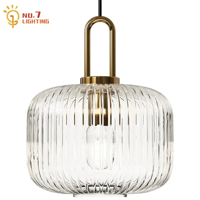 Clear glass pendant light with vertical ridges and brass-finished metal frame for dining room pendant lights
